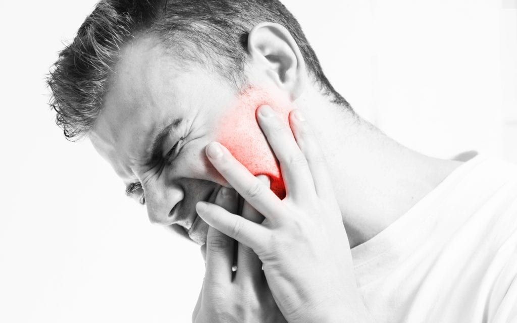 Man holding side of face in pain