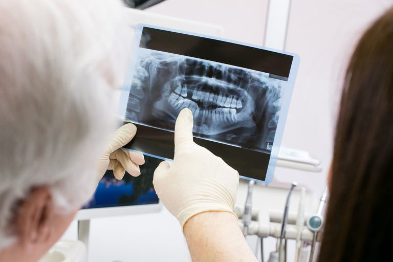 Dentist showing dental xray to patient
