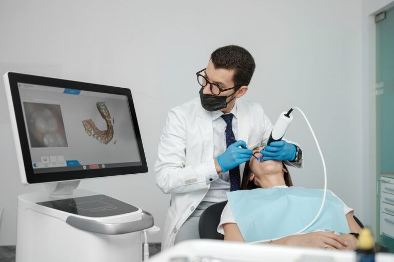 Male orthodontist scaning patient with dental intraoral scanner
