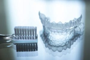 Toothbrush beside a clear aligner