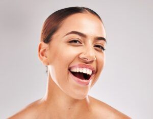 happy female smiling in satisfaction for oral cosmetics, mouth or gum care treatment