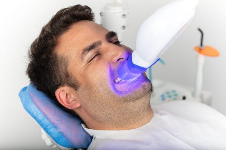 Man undergoing laser teeth whitening treatment to remove blemishes and discoloration.