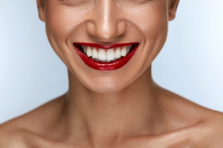 Women smiling with white teeth and red lipstick