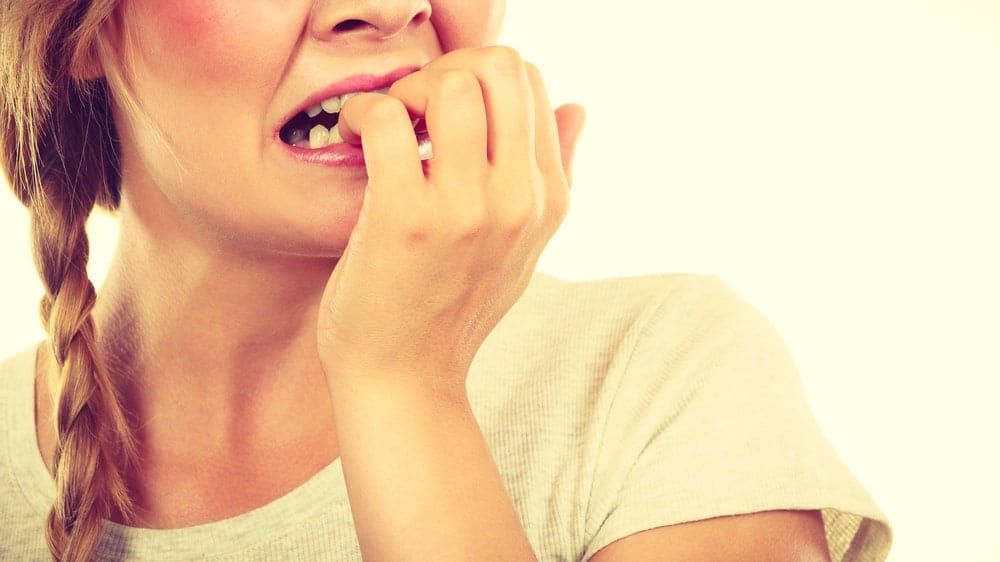 woman anxiously biting her nails