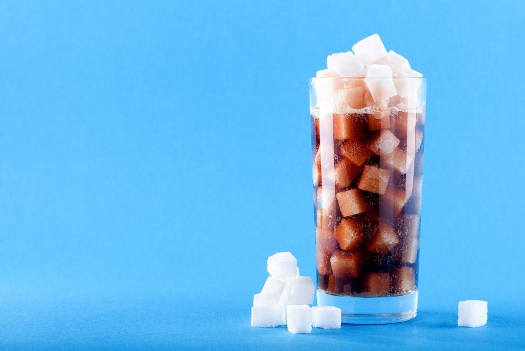 glass of soda filled with sugar