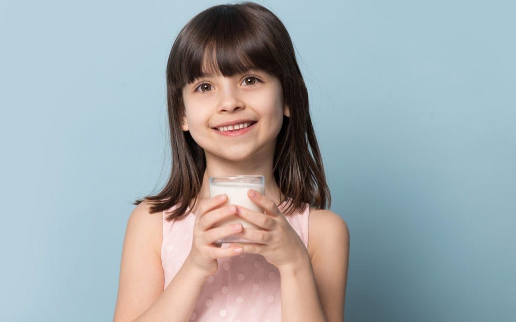 Smiling child with glass of milk
