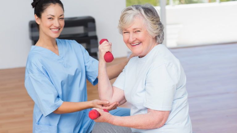 Elderly woman working with a physical therapist
