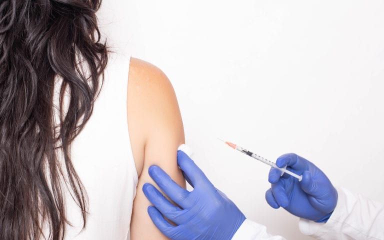 Woman receiving injection in shoulder joint