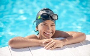 Child at edge of swimming pool smiling