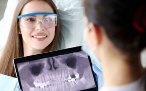 Dentist Looking Over X-Rays With Patient