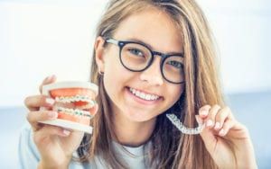 Woman holding braces and invisalign