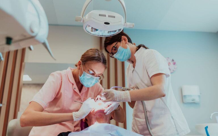 Dentists Helping Patient Through Oral Surgery