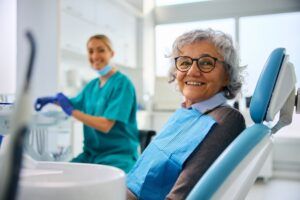 Happy senior woman during dental appointment at the dentist looking at camera.