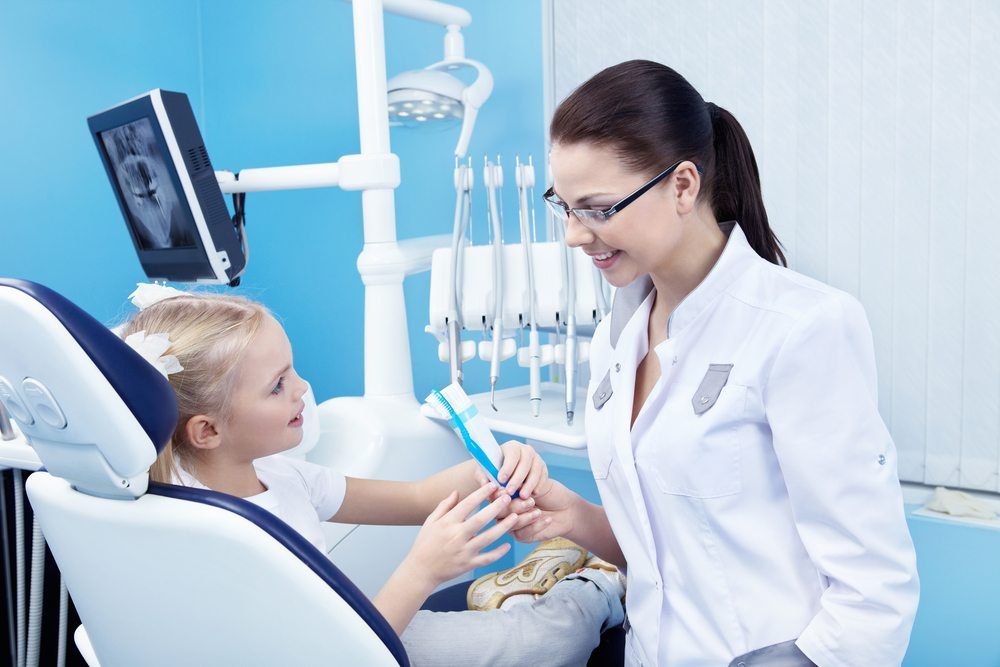 A Female Dentist explaining a kid to brushing teeth procedure  05