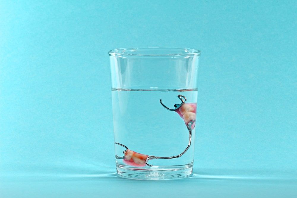 partial dentures in a glass of water