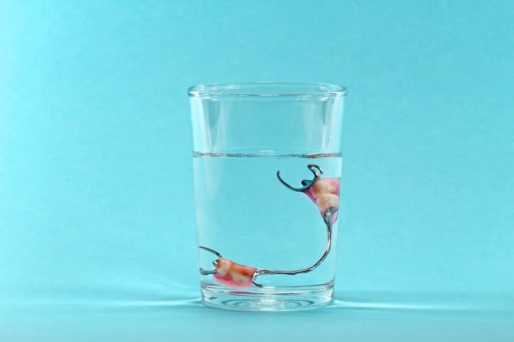 partial dentures in a glass of water