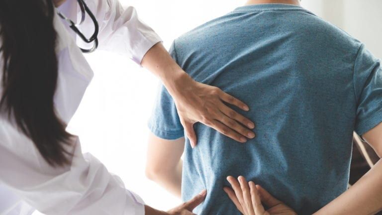 Physician inspecting reports of patients back pain