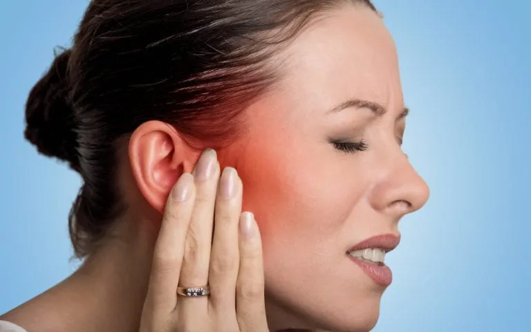 Woman touching face and grimacing from pain
