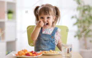 Child at Table Eating Food