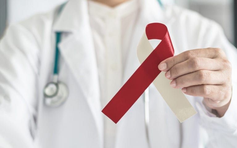 Dentist Holding Up Burgundy Ribbon