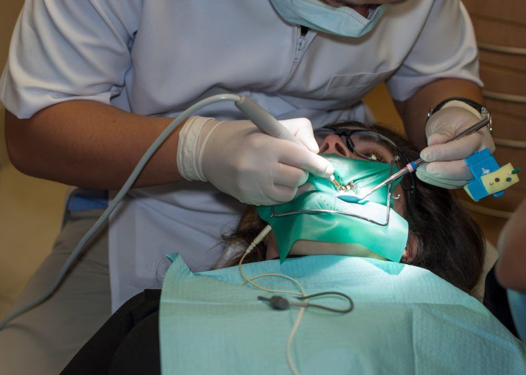 female patient receiving a root canal treatment by male dentist