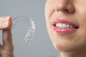 woman holding an Invisalign tray