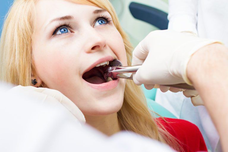 blonde girl receiving a tooth extraction