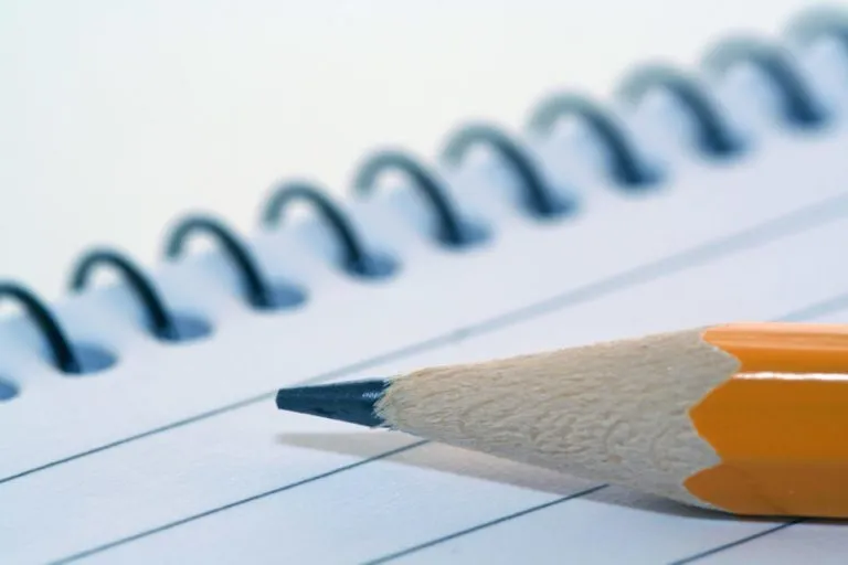 notepad with pencil on top