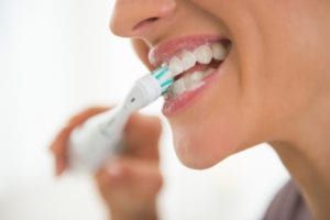 woman brushing teeth with Electric Brush