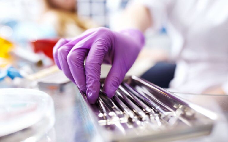 Oral Surgery Tools Used By Dentist's Hand Closeup