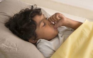 Child sleeping while sucking thumb